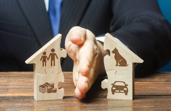 Puzzle house is divided into two equal parts by a lawyer in a divorce process. Protection of rights. Conflict resolution. Court, justice. Disputes over fair division of marital property real estate.